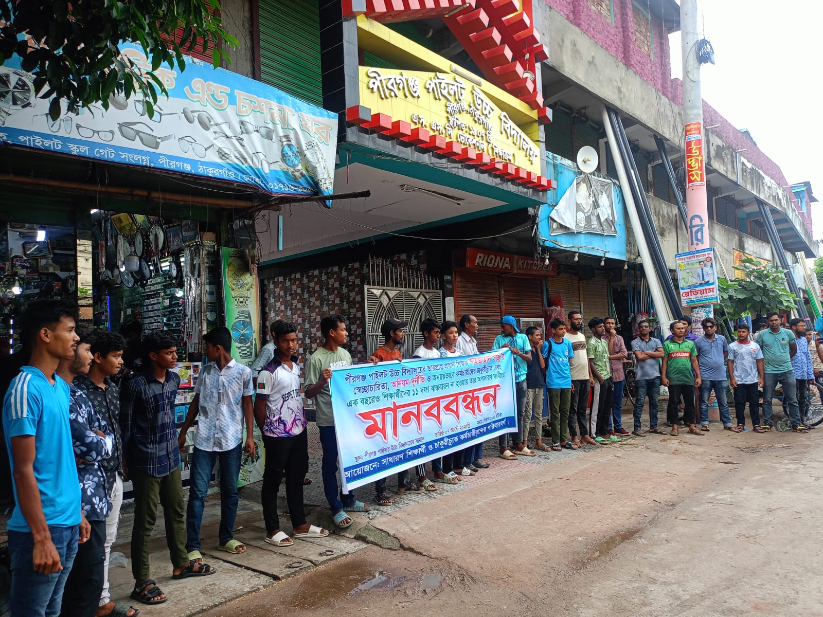 পীরগঞ্জে পাইলট উচ্চ বিদ্যালয়ের সামনে সাধারণ শিক্ষার্থী ও চাকরীচ্যুত কর্মচারীদের পরিবারর্গের ব্যানারে মানবন্ধন